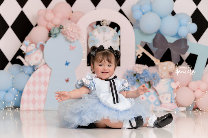 Whimsical Wonderland Tea Party backdrop with pastel balloons, tea props, and keyhole design.