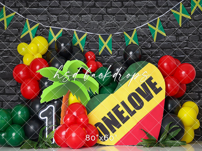 One Love Jamaican party backdrop with colorful balloons, flag bunting, and heart sign.