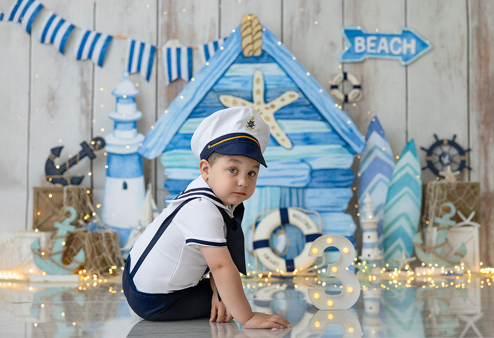 Ahoy Little Sailor nautical beach photography backdrop with lighthouse, anchors, and surfboards.