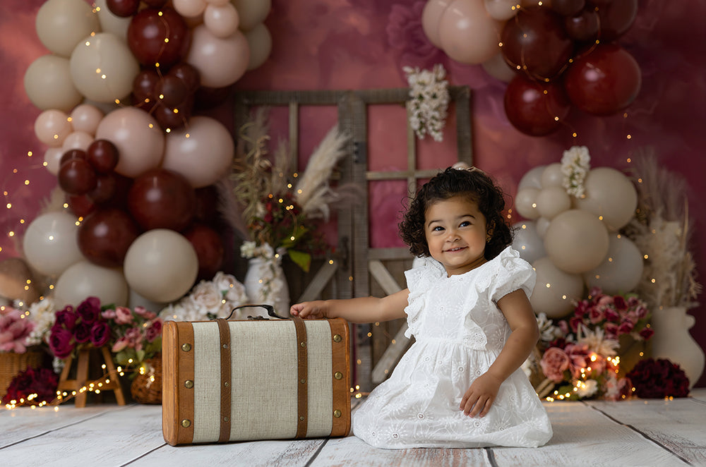 Rustic Velvet Garden backdrop with burgundy balloons, barn doors, florals, and mushrooms.