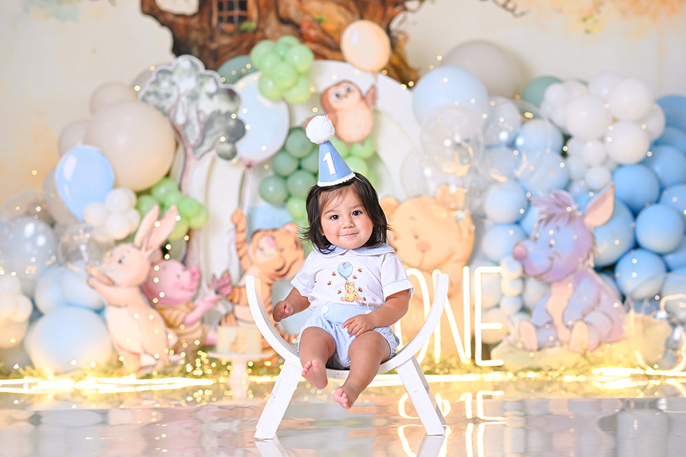 Whimsical storybook birthday backdrop with tree, balloons, and woodland characters