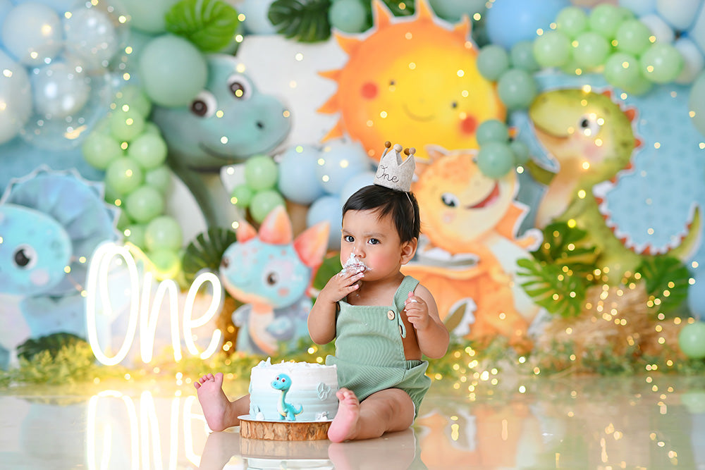 Prehistoric pastel dinosaur birthday photo backdrop with balloons and smiling sun.