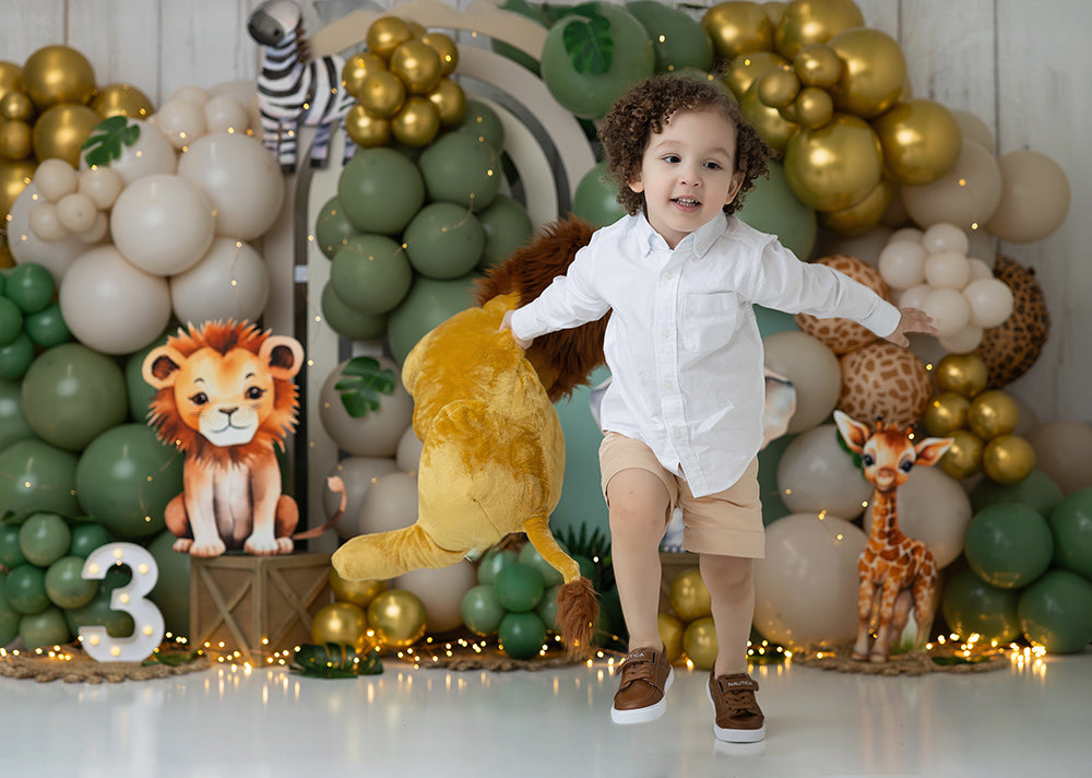 Jungle-themed safari birthday balloon backdrop with lion, elephant, and giraffe
