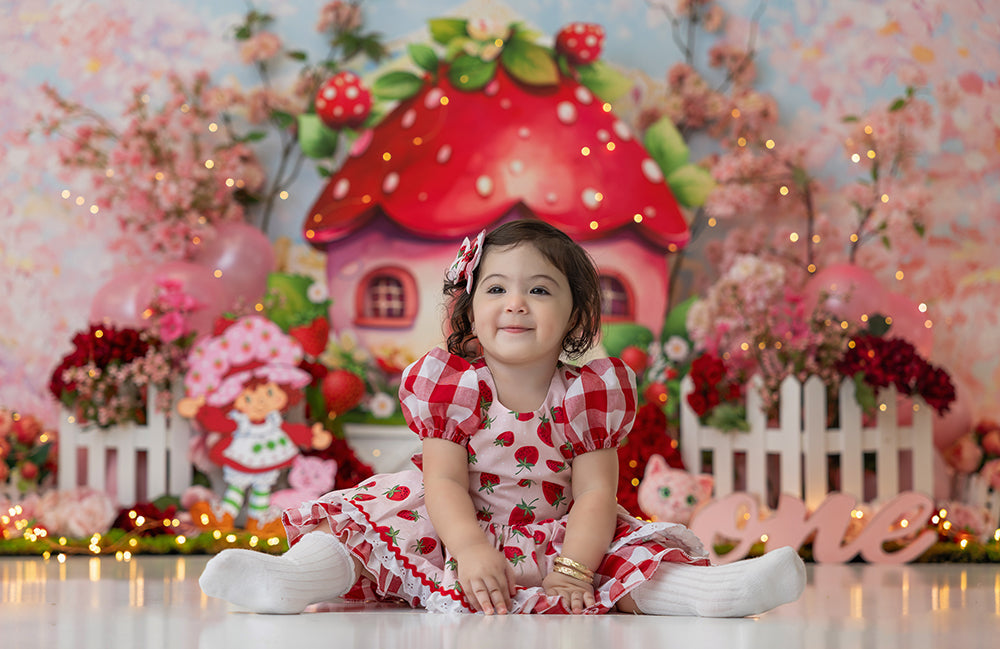 Sweet Berry Chalet strawberry cake smash backdrop with red mushroom house, florals, and strawberry theme