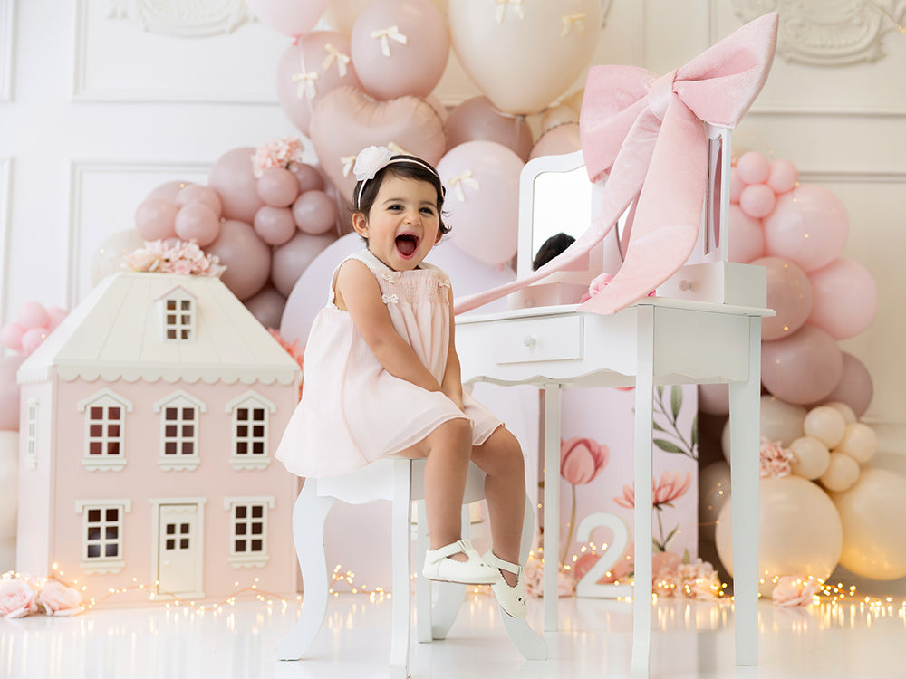 Pretty in Blush backdrop with pink dollhouse, florals, and blush balloon garland