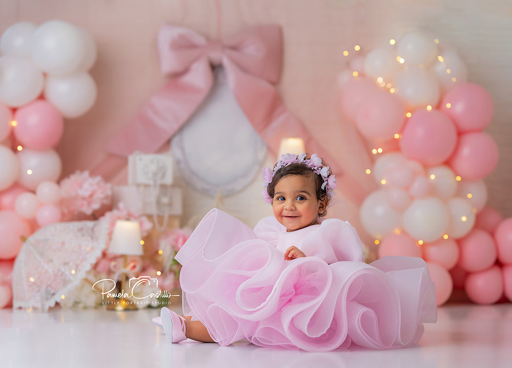 Blush pink photography backdrop with balloons, florals, and large bow