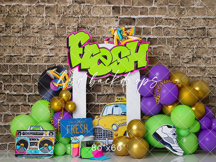 Fresh One Birthday Bash backdrop with graffiti “Fresh” sign, balloons, taxi, and hip hop props