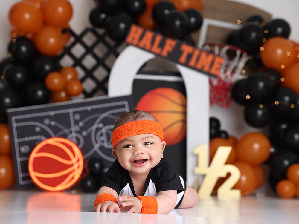 Halftime Hoops backdrop with orange and black balloons, basketball court, and hoop
