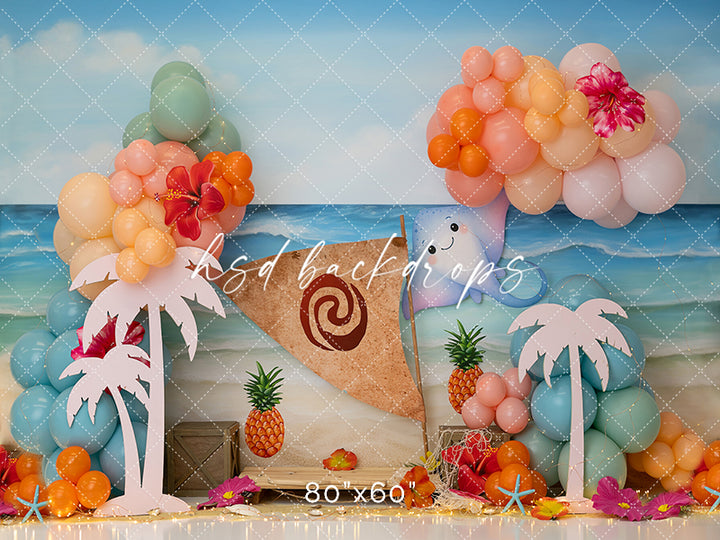 Tropical Island Adventure beach party photography backdrop with palm trees, balloons, pineapples, and ocean waves.
