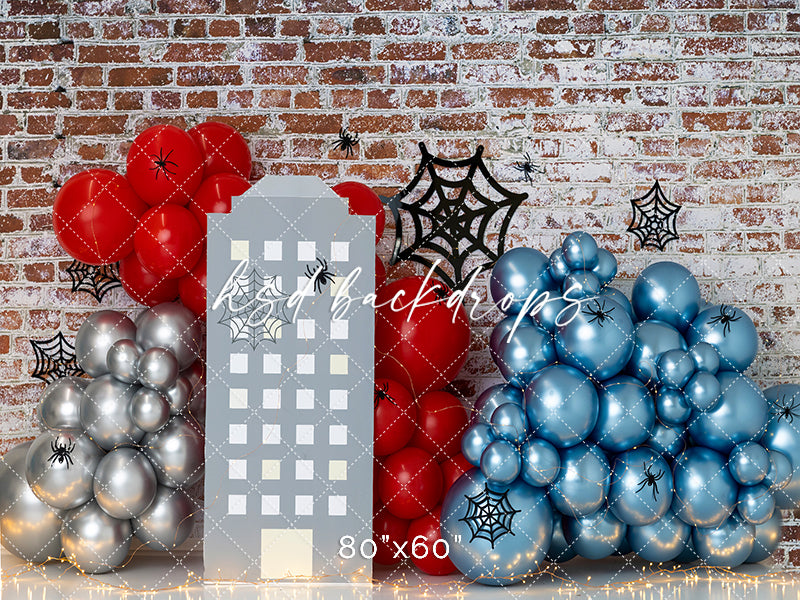 Web of Fun superhero cityscape backdrop with red and blue balloons, spider webs, and brick wall background for kids’ birthday or cake smash photography.