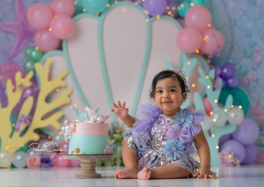 Under the Sea Shell mermaid cake smash photography backdrop with seashell, coral, and ocean balloons.