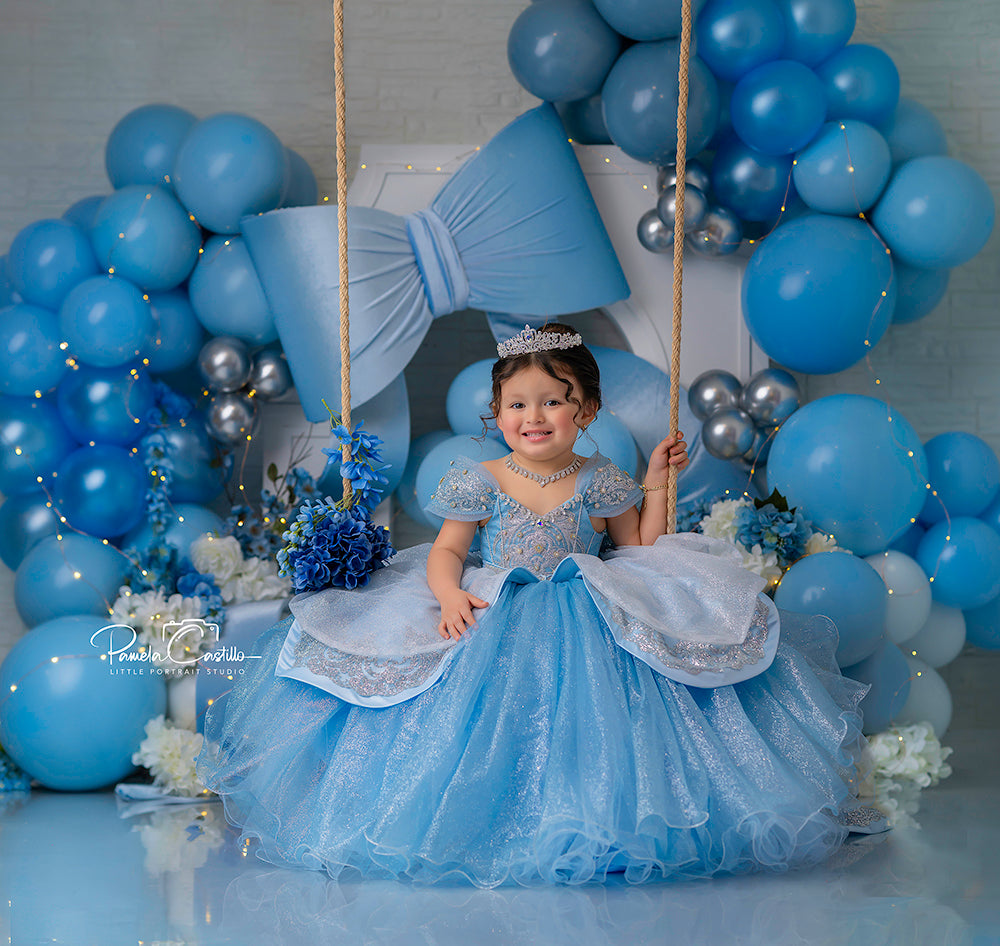 Blue Bow Celebration photography backdrop featuring a large satin bow, blue and silver balloons, and white floral accents for baby showers, birthdays, and cake smash sessions.