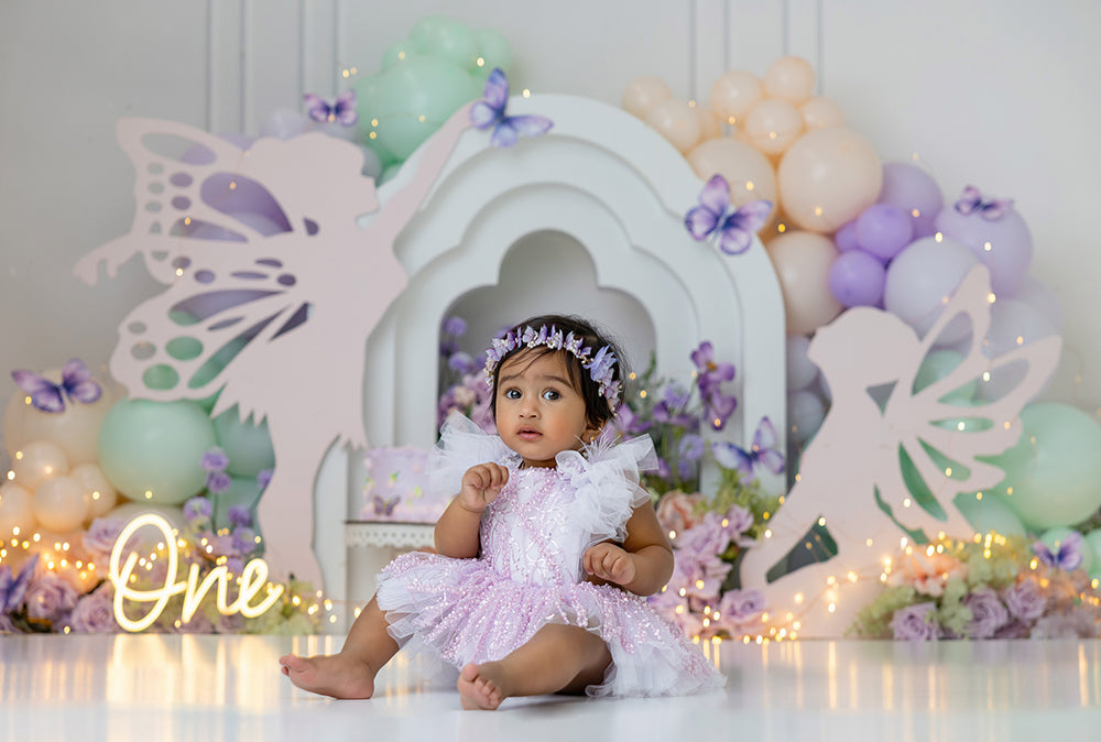 Pastel fairy garden backdrop with balloons, butterflies, florals, and whimsical fairy silhouettes