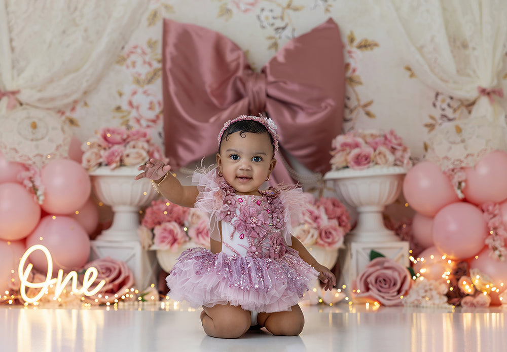 Vintage pink bow cake smash backdrop with roses, lace, florals, and pastel balloons