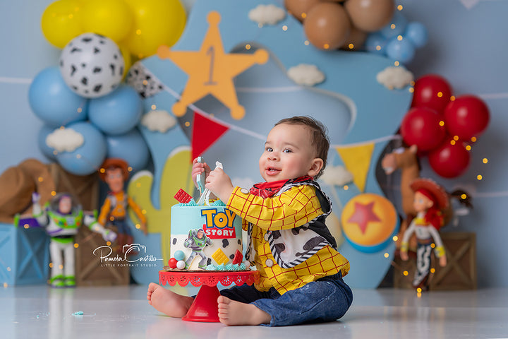 Wild West One cowboy first birthday cake smash backdrop with balloons and cacti.