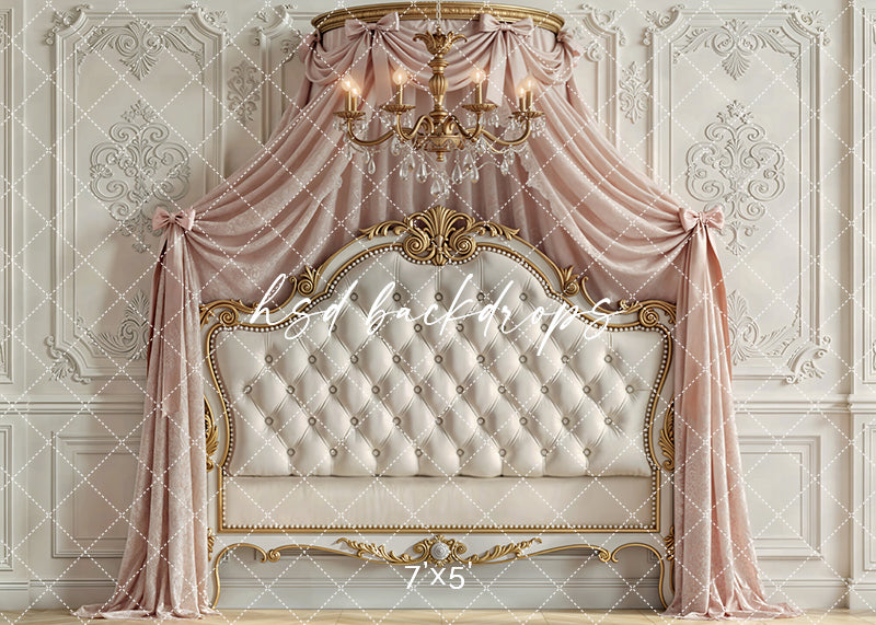 Elegant blush and ivory princess canopy with gold accents, tufted headboard, draped fabric, and chandelier for fairytale children's photography.