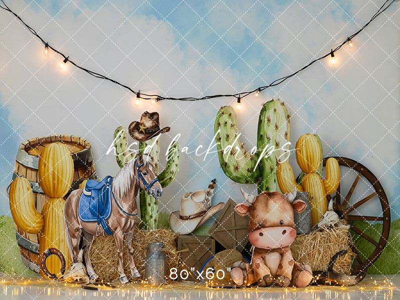 Western birthday backdrop with cacti, horse prop, hay bales, cowboy hats, and baby cow for desert-themed cake smash photography.