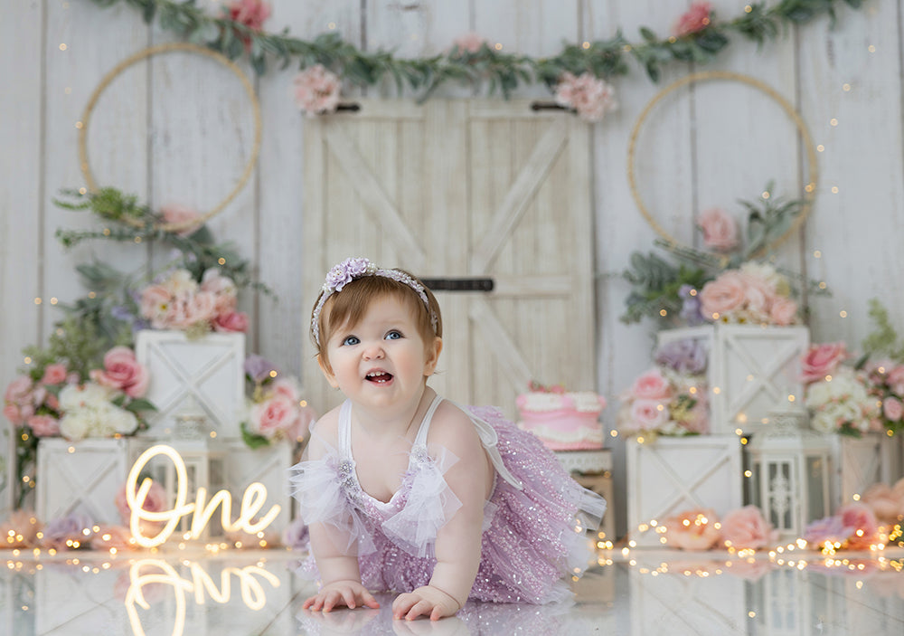 Blush floral barn door cake smash photography backdrop with rustic farmhouse decor, first birthday portrait background.