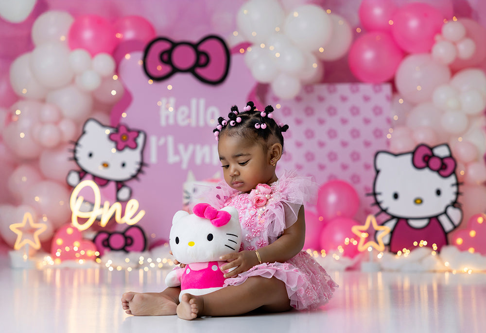 Hello Pink Dreams cake smash photography backdrop with pink bows, white and pink balloon clusters, and whimsical first birthday styling.