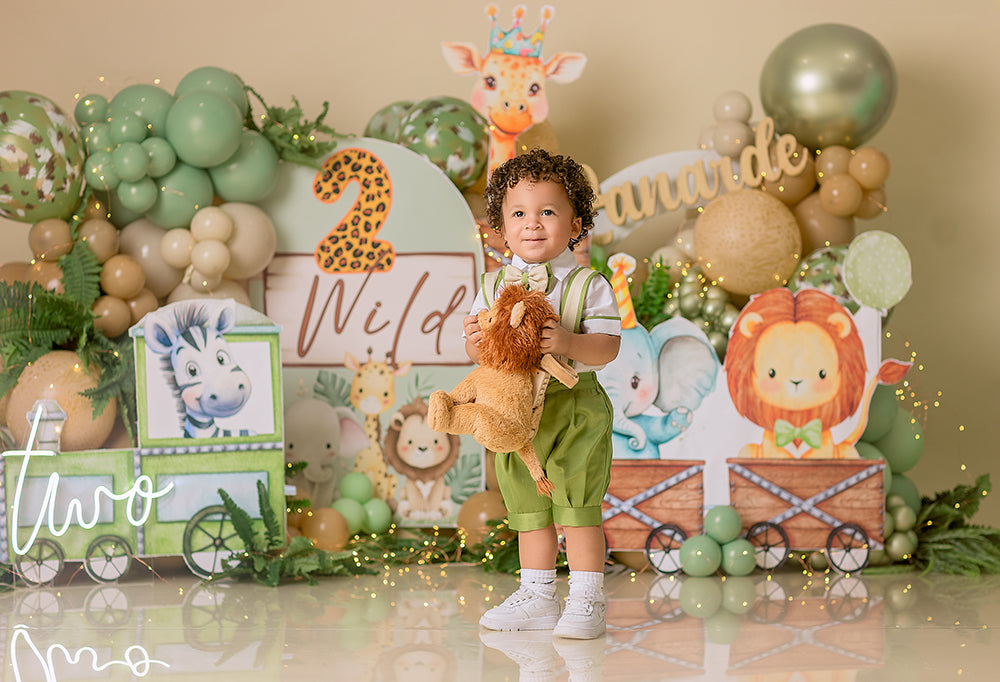 2 Wild safari cake smash photography backdrop with jungle animals, green balloon clusters, and boys 2nd birthday styling.