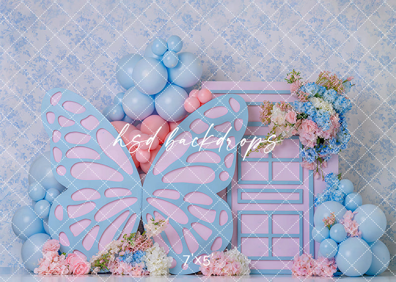 Pastel butterfly door photography backdrop with oversized butterfly wings, pink door, soft blue and pink balloons, and floral accents for girls birthday portraits.