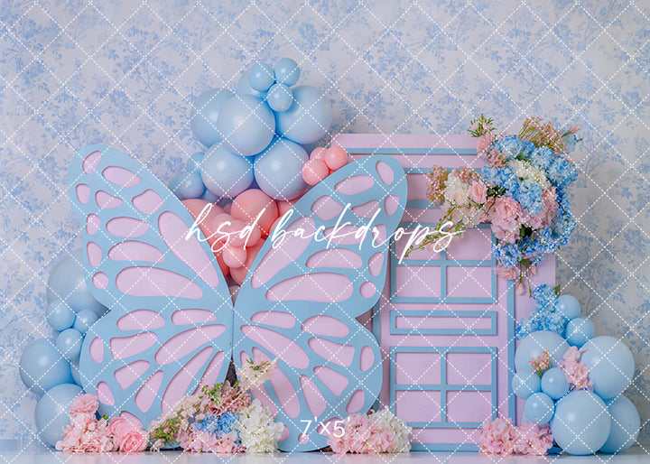 Pastel butterfly door photography backdrop with oversized butterfly wings, pink door, soft blue and pink balloons, and floral accents for girls birthday portraits.